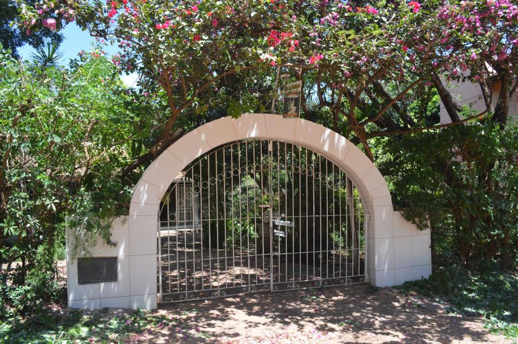 een poort in een tuin met roze bloemen bij Pousada Dos Henriques in Lençóis