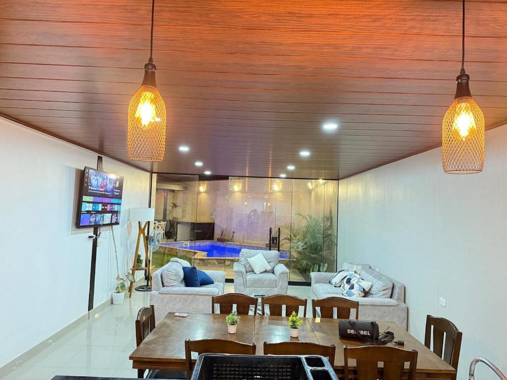 a living room with a table and a couch at Pool house, garden, grill in Ica