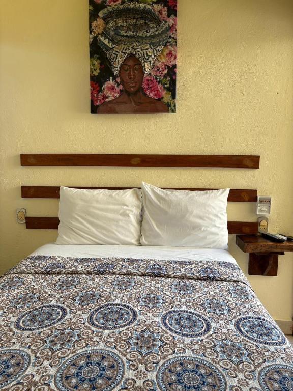 a bed in a bedroom with a picture on the wall at Casa Piedra Parada in Brisas de Zicatela
