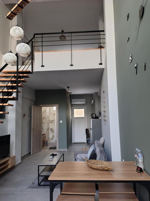 a living room with a table and a staircase at Konstantinos Loft in Serres