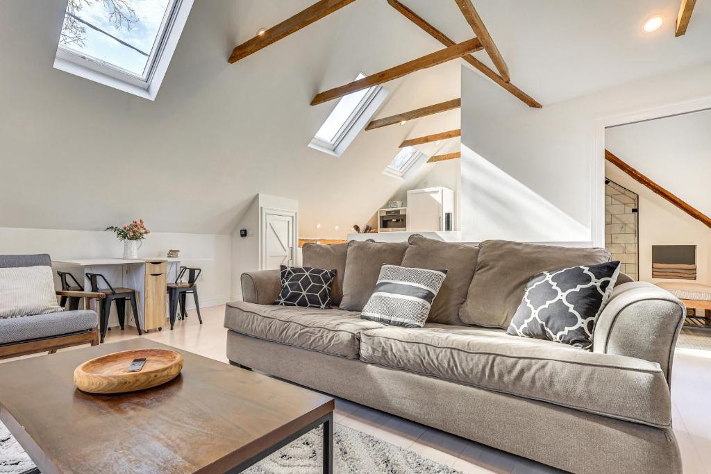 a living room with a couch and a table at Steps to NYC Train! Charming Carriage House Loft in Glen Ridge