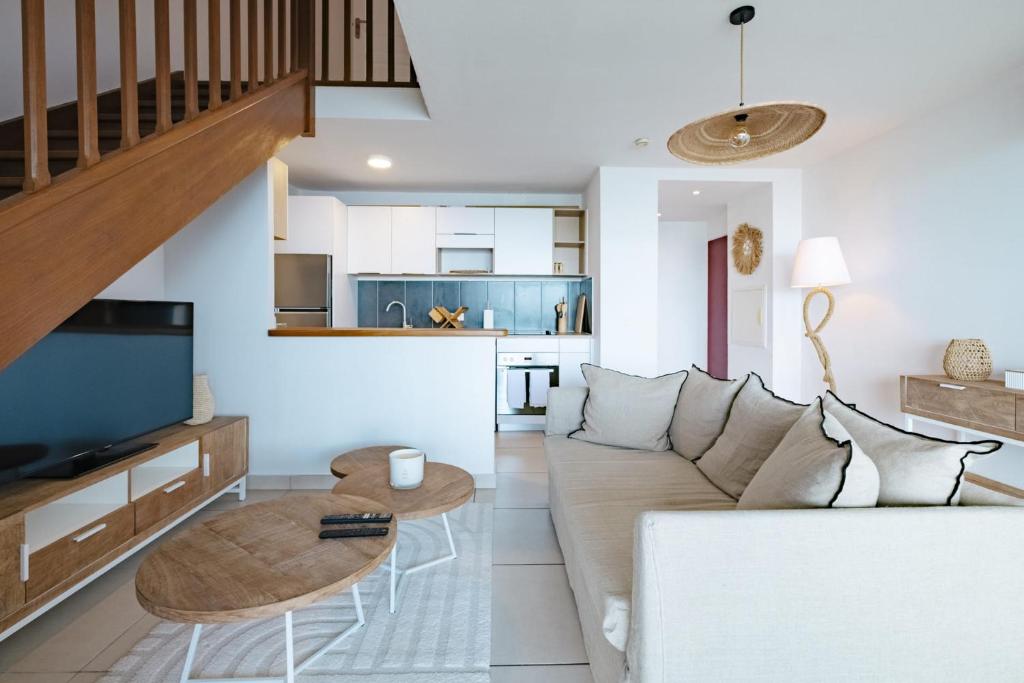 a living room with a couch and a table at Appartement Reflets Marins in Saint Martin