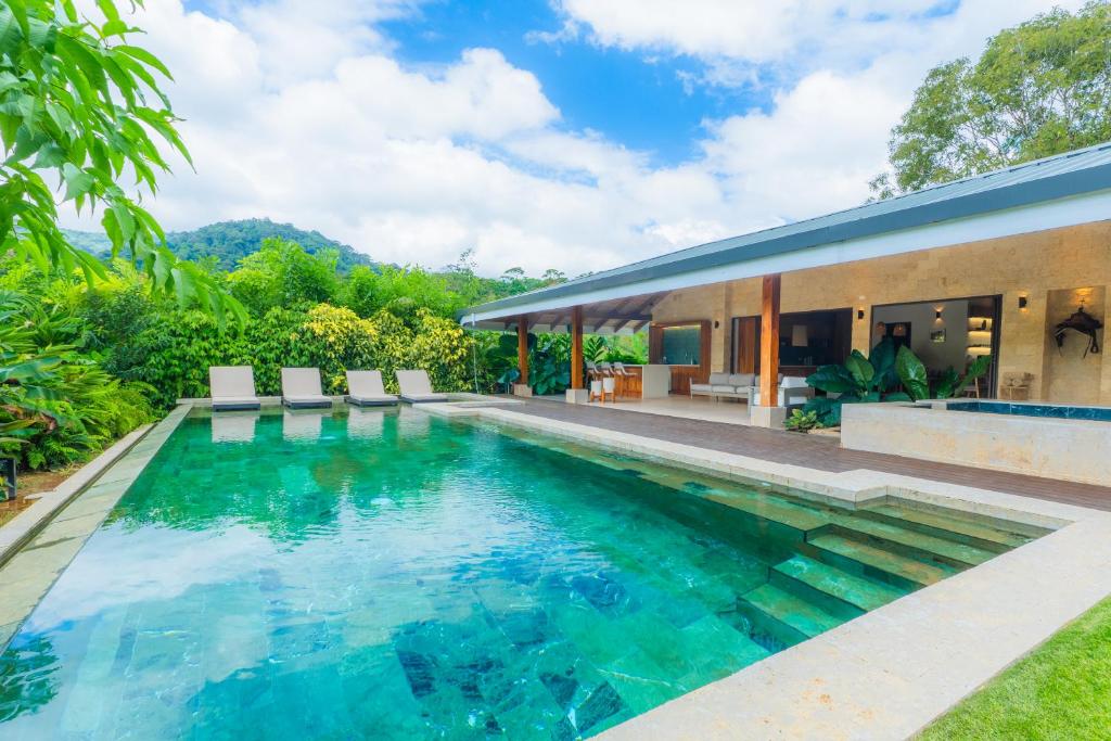 a swimming pool in front of a house at Chachagua Rainforest Hotel & Hot Springs in Fortuna