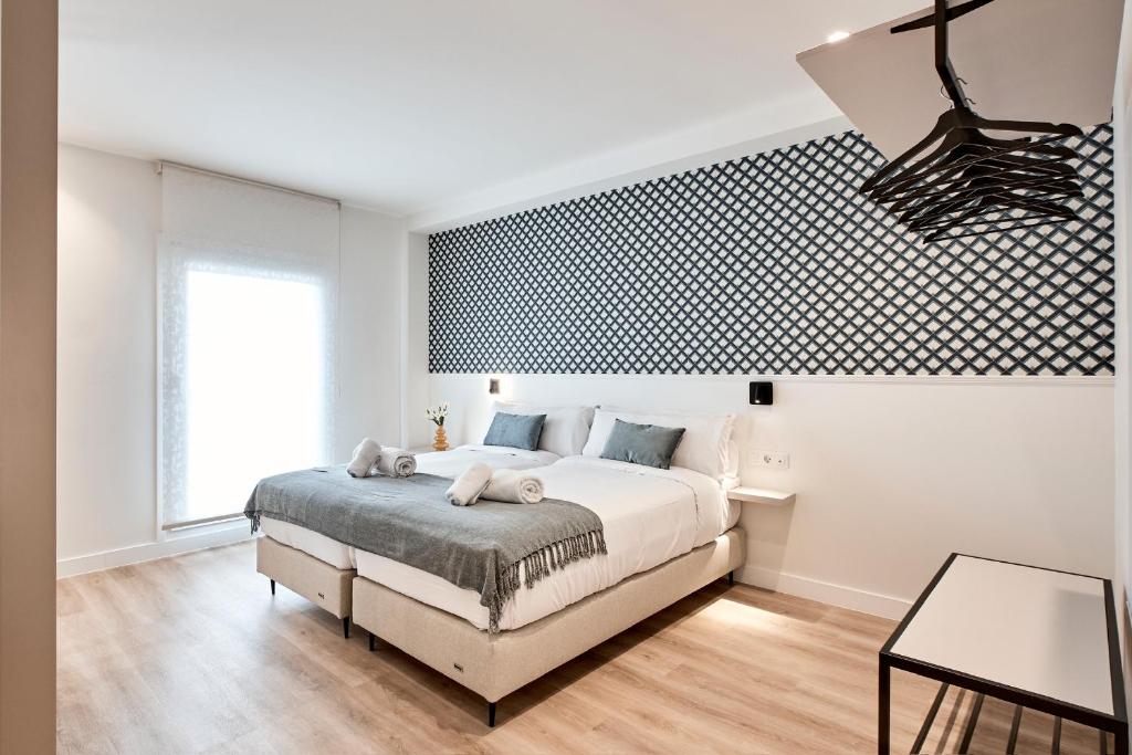 a bedroom with a bed and a black and white patterned wall at Agora Palas in Palas de Rei