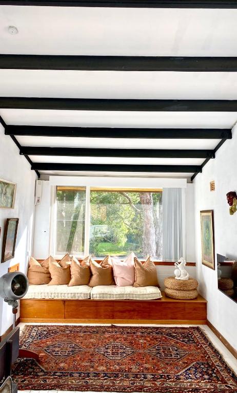 a white couch in a room with a window at MELLOW TREES Lake front studio with sauna in Budgewoi