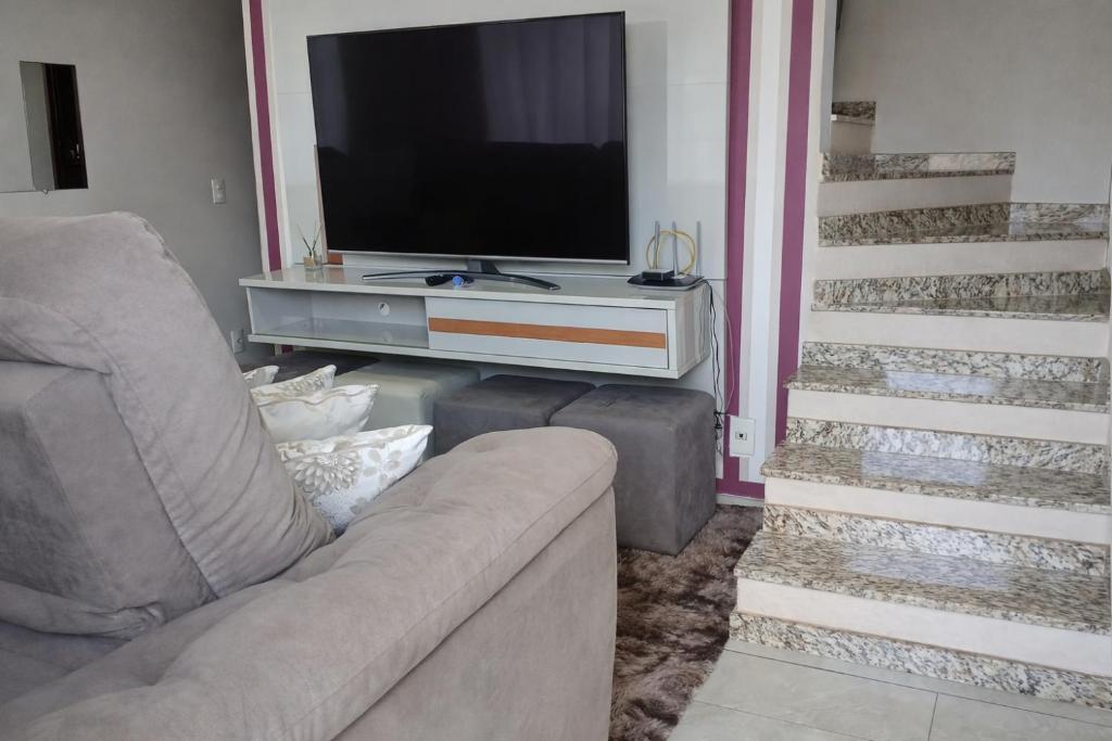 a living room with a couch and a flat screen tv at Um verdadeiro Spar, Para descansar e meditar in Vinhedo