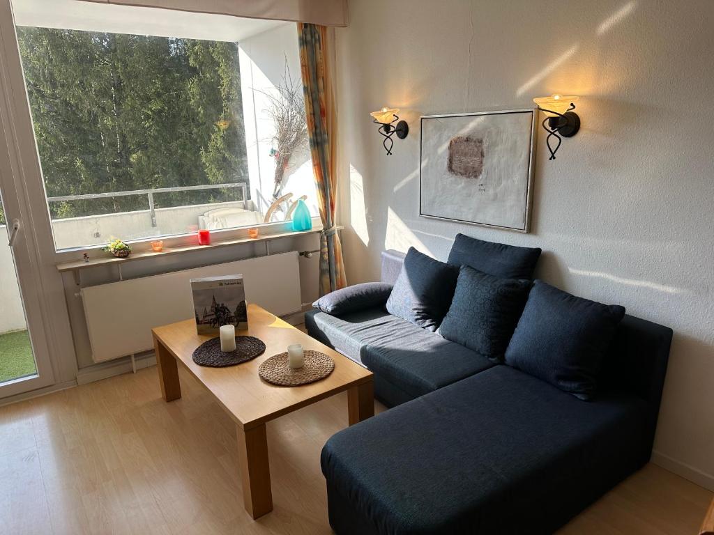 a living room with a blue couch and a table at Ferienwohnung Relax 1 in Hahnenklee-Bockswiese