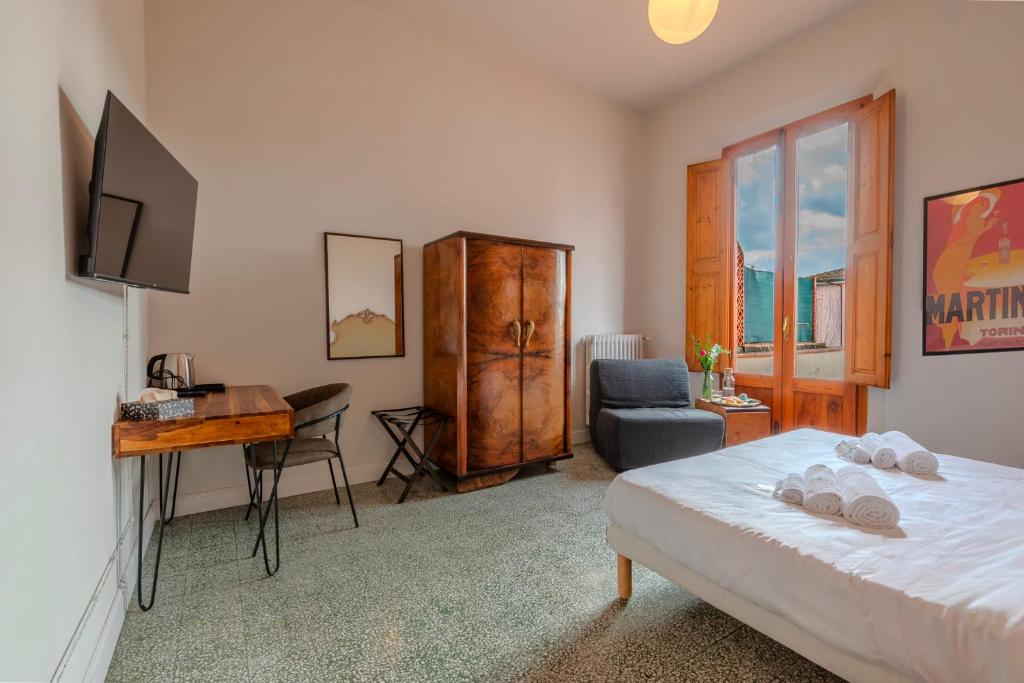 a bedroom with a bed and a desk and a chair at Casa Altini in San Miniato