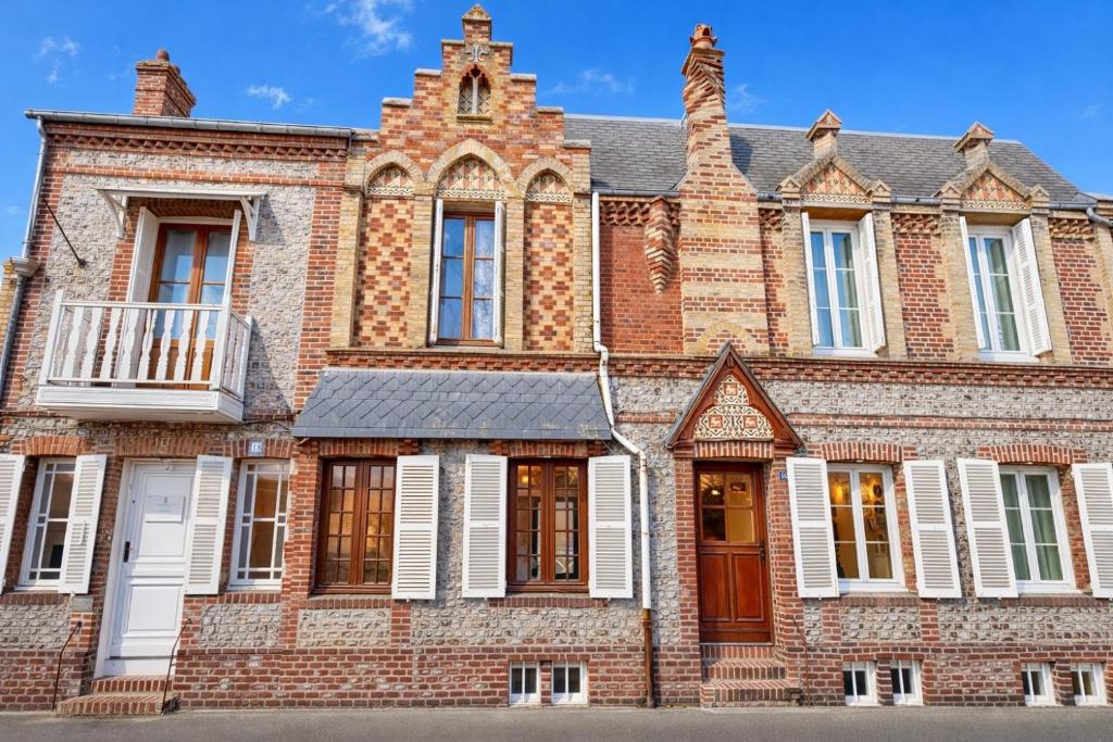 an old brick building with white shuttered windows at Villa Ancestor - Etretat in Étretat