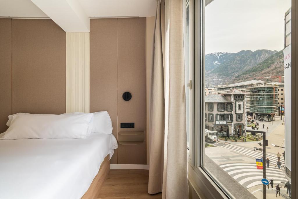 a bedroom with a bed and a large window at LEE Hotel in Andorra la Vella