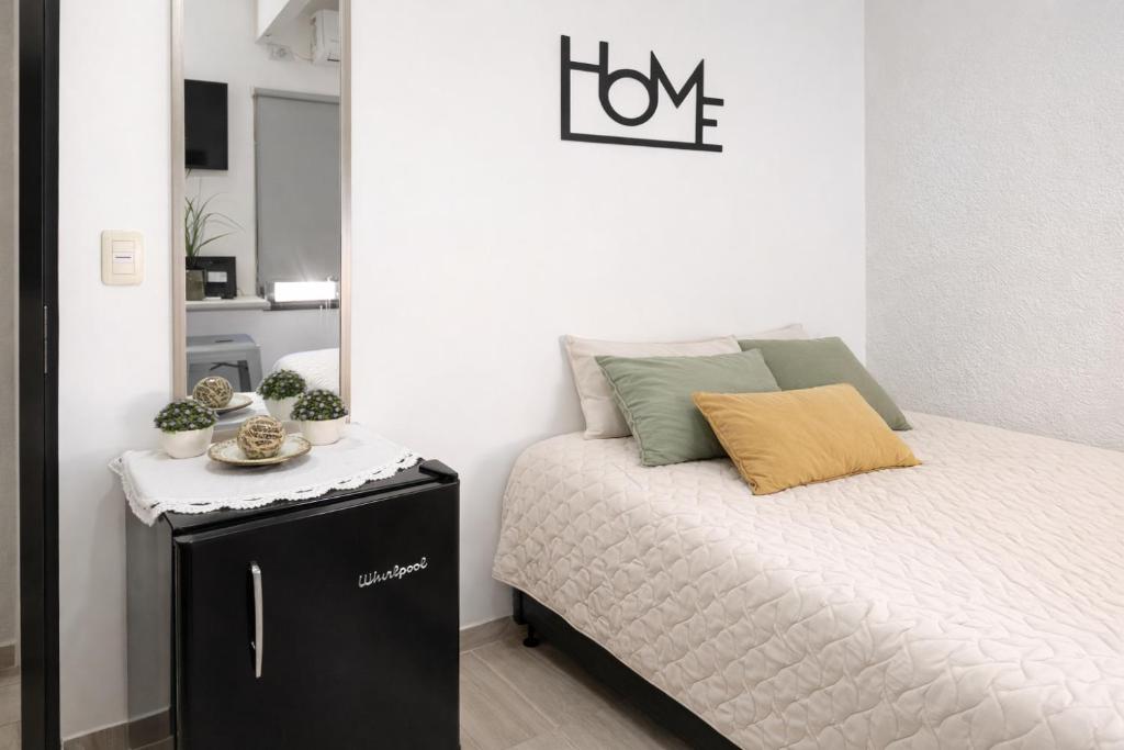 a small bedroom with a bed and a mirror at Departamento Moderno, equipado en Vicente Lopez , Ideal River Plate ,Tecnópolis ,100 metros del tren in Vicente López