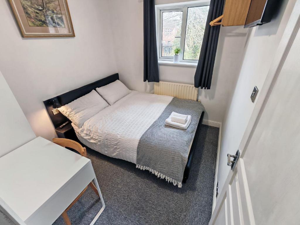 a small bedroom with a bed and a window at Small Compact Self Contained Studio Flat in Oxford