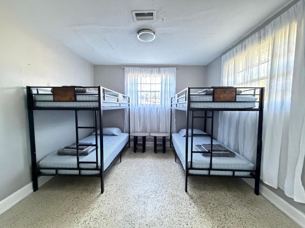 two bunk beds in a room with a window at Bek's Hostel in Hallandale Beach