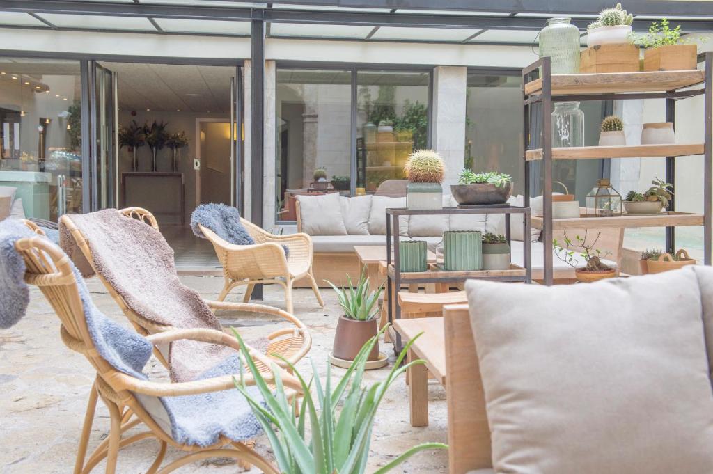 a patio with chairs and plants and a couch at Petit Palace Hotel Tres in Palma de Mallorca