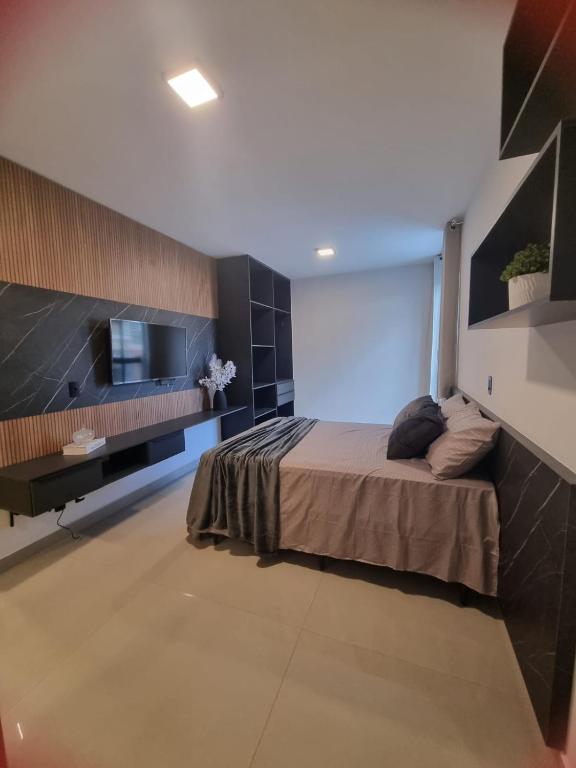 a bedroom with a bed and a flat screen tv at Studio Proximo Anashopping Kitnet 101 in Anápolis