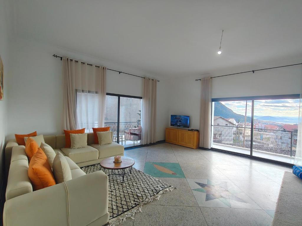 a living room with a couch and a large window at Apartment amina in Azrou