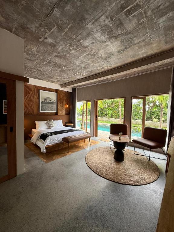 a bedroom with a bed and a table and chairs at Koji Collection in Kerobokan