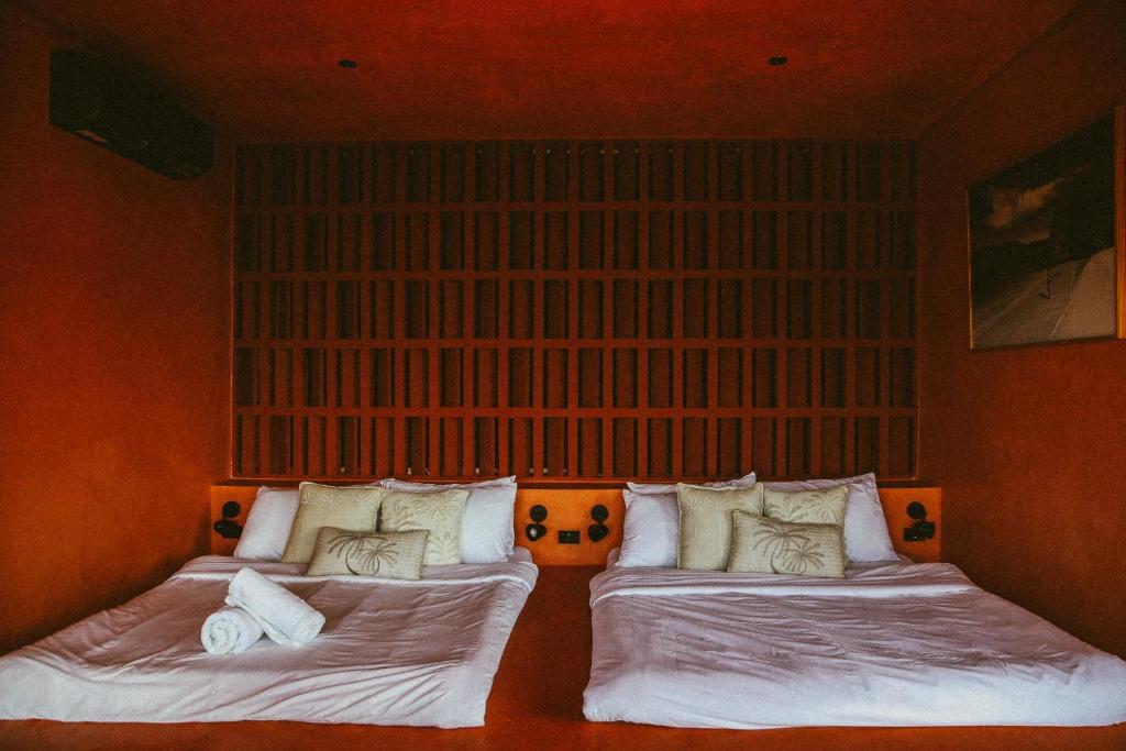 two beds in a room with a large window at C South Hideout in Butong