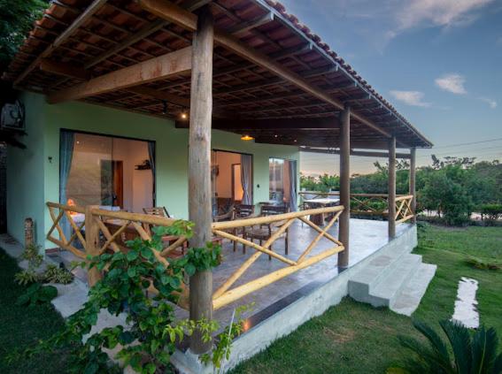 a house with a porch with a wooden deck at Chalé Lar do Capão in Vale do Capao