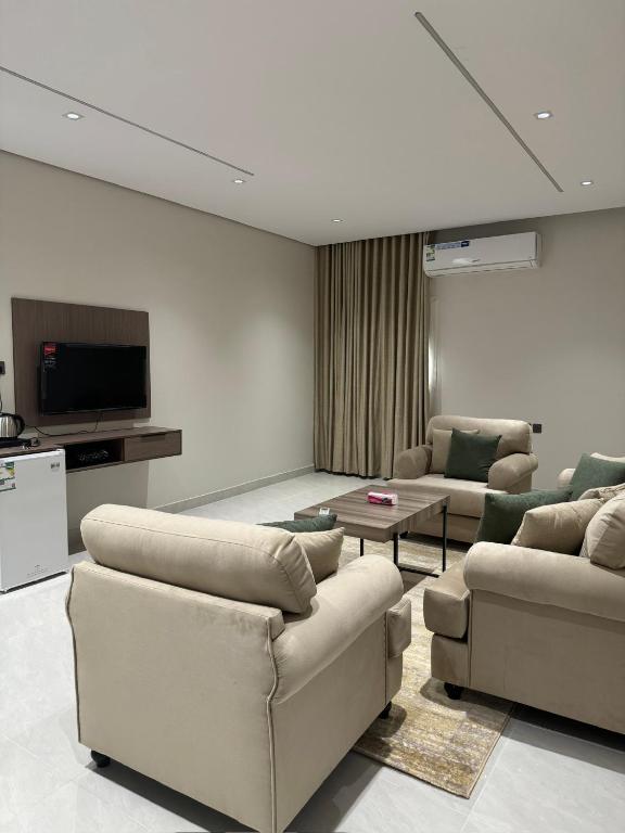 a living room with couches and a flat screen tv at شقق طلال الفندقية- Talal hotel apartments in Al-ʿUla