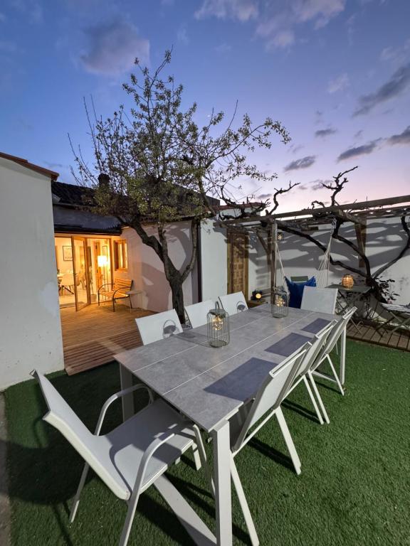 a table and chairs on a lawn with a tree at La Casa de Célia in Valencia de Don Juan