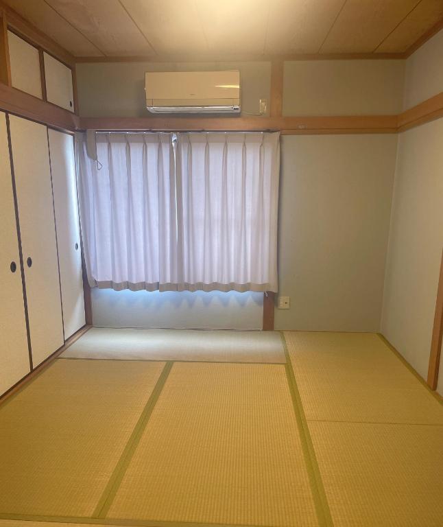 an empty room with a window and a mattress at 桃谷民宿 in Osaka