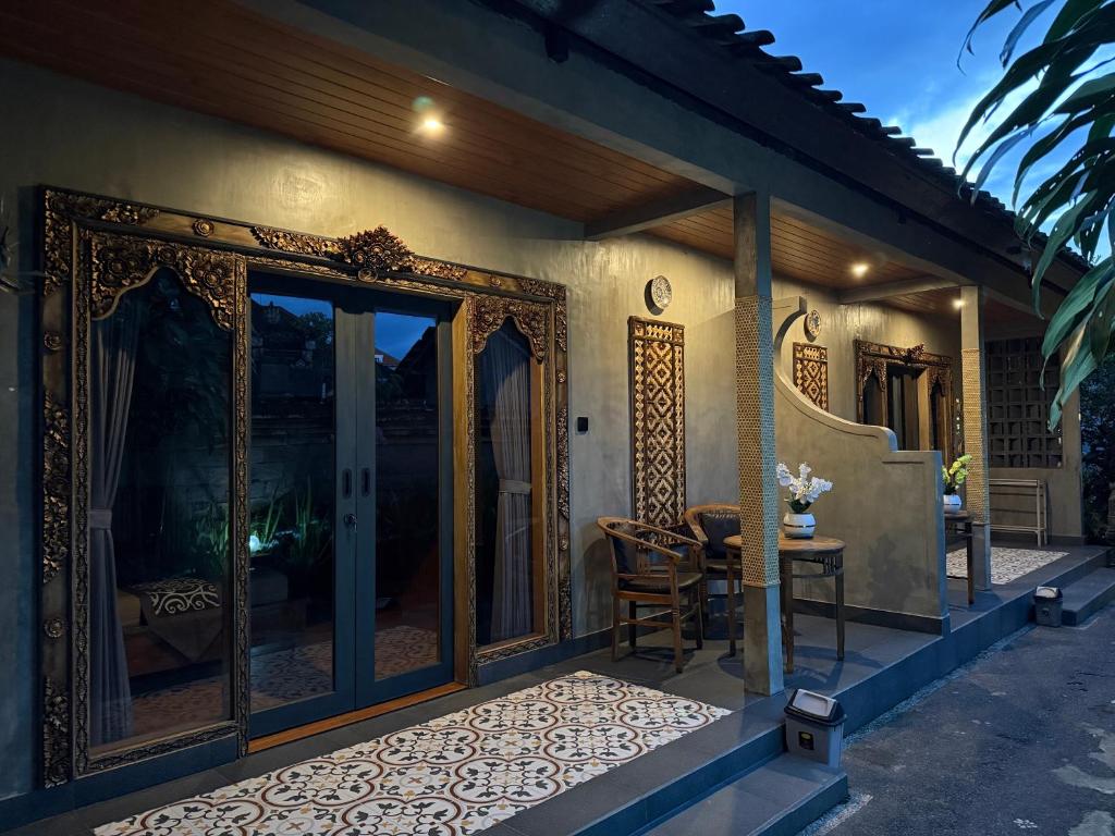 a patio with a table and a glass door at Eka's Homestay in Ubud