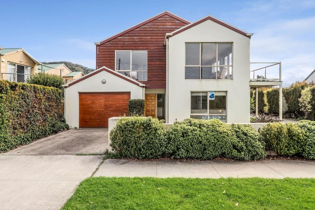 a house with a garage and bushes at The Dunes 1 - BYO Linen in Apollo Bay