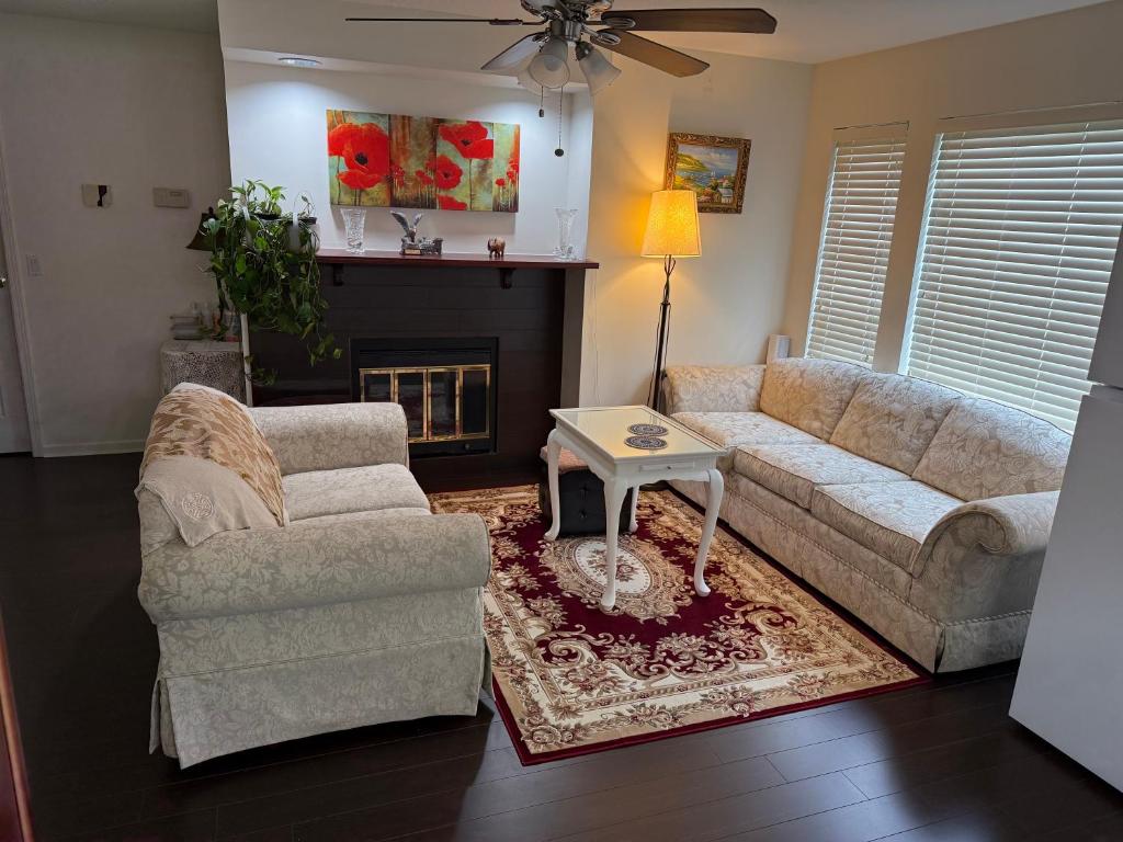 a living room with a couch and chairs and a fireplace at As You Wish Suites & Rooms Near YVR with Parking in Richmond