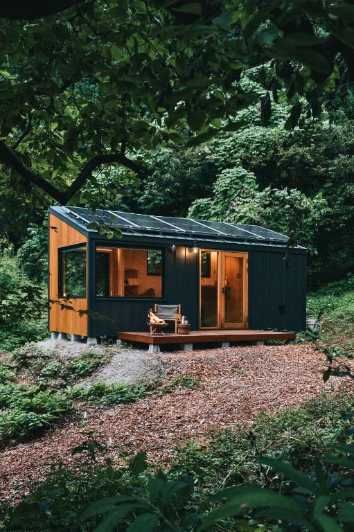 a green tiny house sitting in a field at awake Gojome in Akita