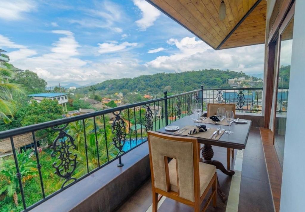 a balcony with a table and a view at Kings Ridge Kandy in Kandy