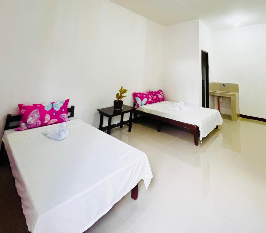 a room with two beds and pink pillows at ChicPoint Guesthouse in Sampong
