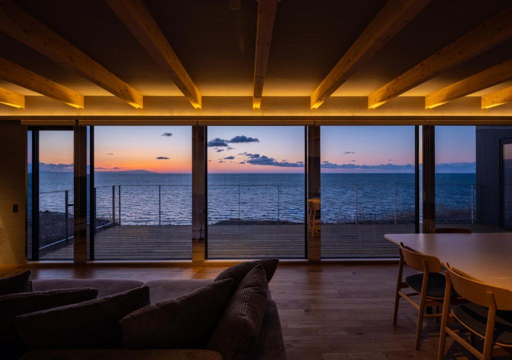 a living room with a view of the ocean at Yunagi 夕凪プライベートサウナ付ヴィラオーシャンフロントの絶景宿 夕日とサウナを満喫海と夕日に包まれる贅沢空間 in Mōrai