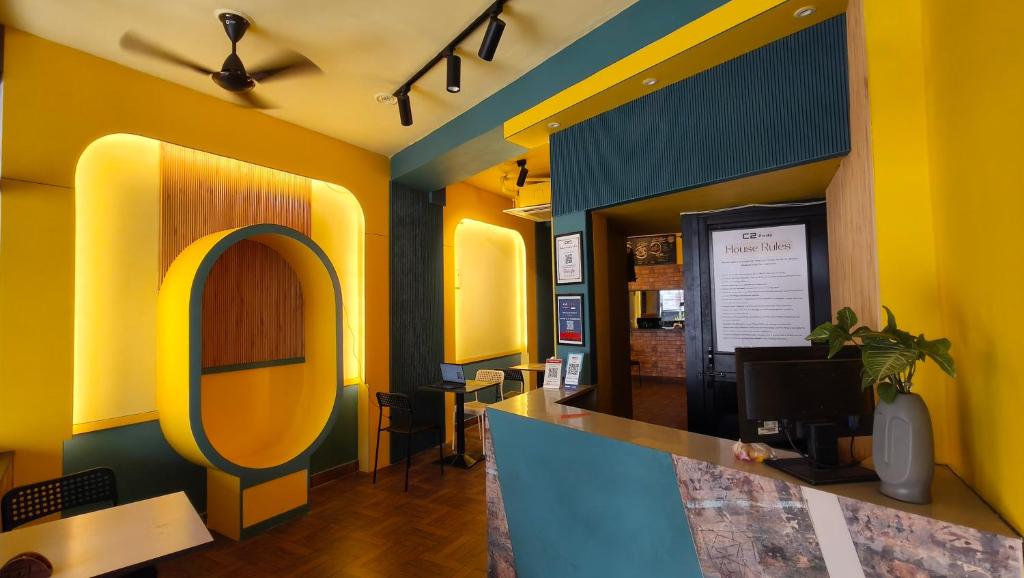 a restaurant with yellow and blue walls and a counter at C2 Pods in Varanasi