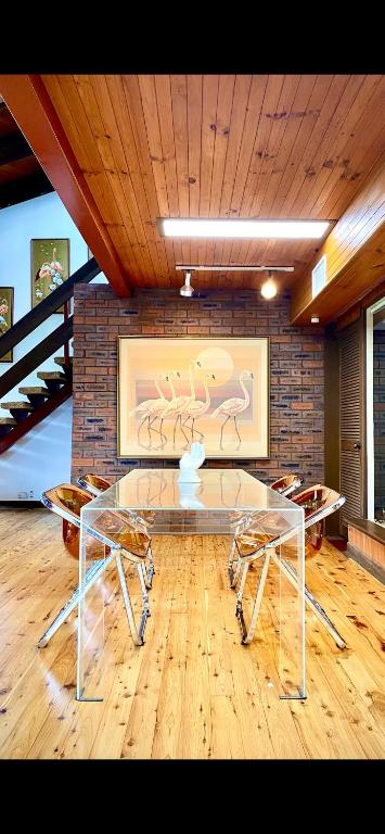 a room with a table and chairs and a brick wall at Lake front, Mid-century house with sauna 2 in Budgewoi