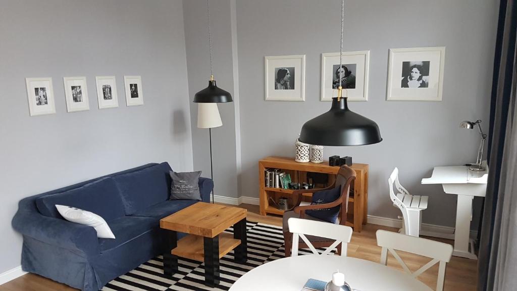 uma sala de estar com um sofá azul e uma mesa em Przy Poli Negri em Bydgoszcz