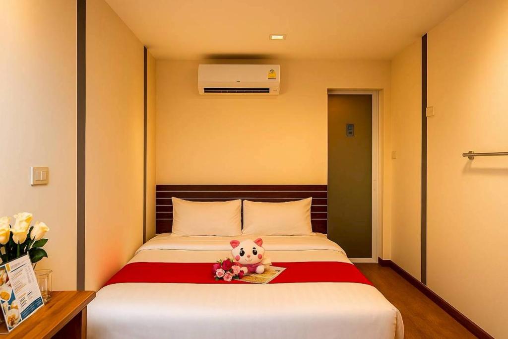 a bed with a teddy bear sitting on top of it at innbox Chiangmai Hotel in Ban Si Ngam