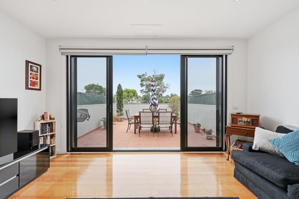 a living room with a couch and a dining table at Tide & Town - Perfectly Located! in Inverloch