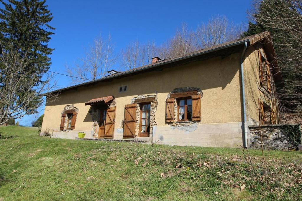 an old house with boarded up windows in a field at Sous les serves in Saint-Léonard-de-Noblat