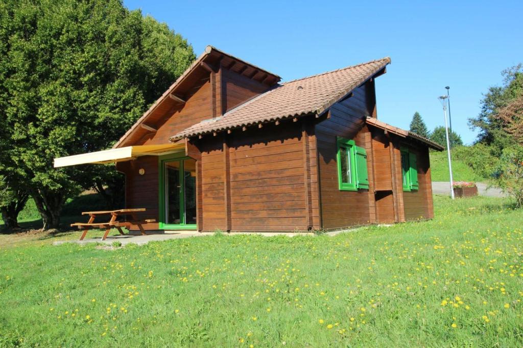 a small wooden cabin with a picnic table in a field at Gîte 87G5511 in Sussac