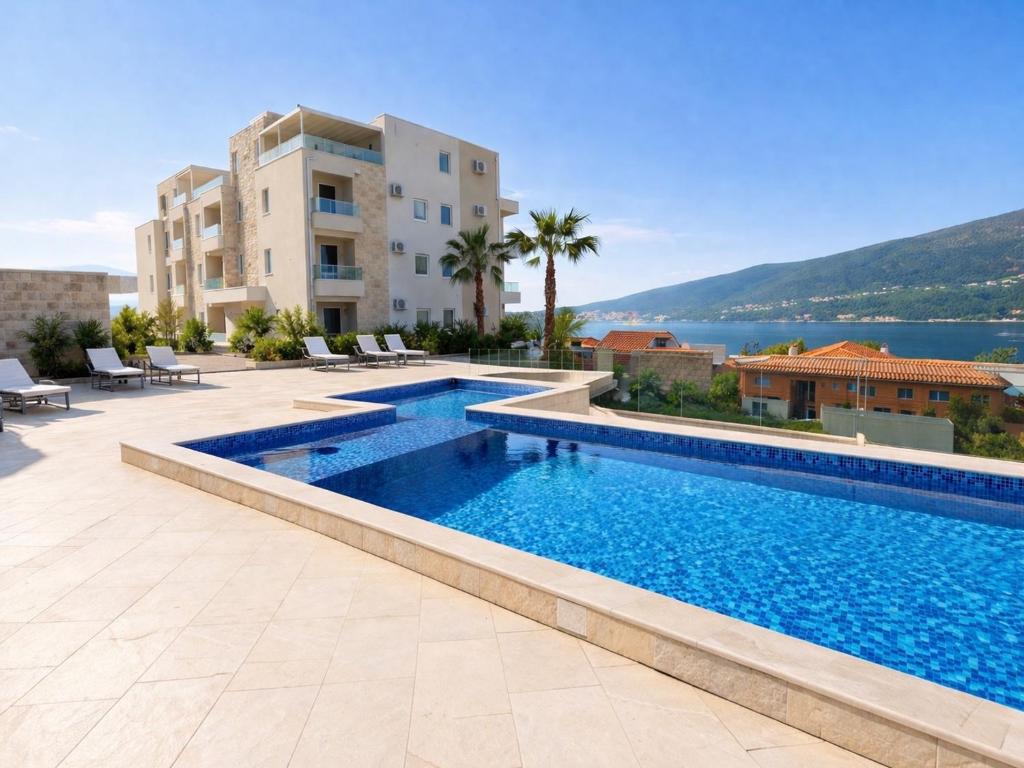 a swimming pool with a view of a building at Bella Vista Residence with private Free Parking in Baošići