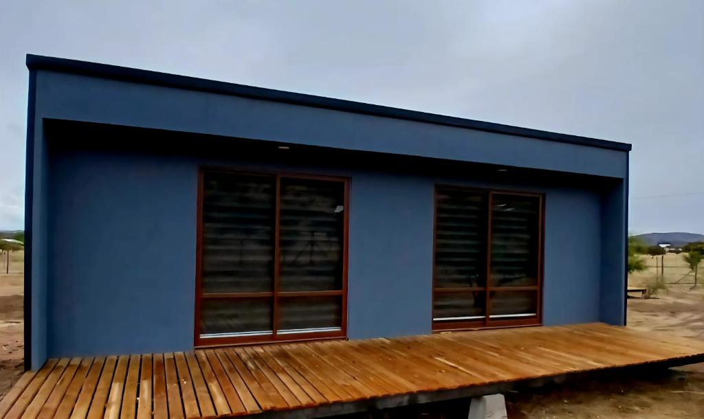 a blue building with windows on a wooden deck at Tiny por trabajo in Trinidad