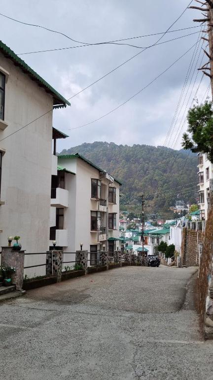an empty street with buildings and a mountain in the background at Pine Galaxy in Bhowāli
