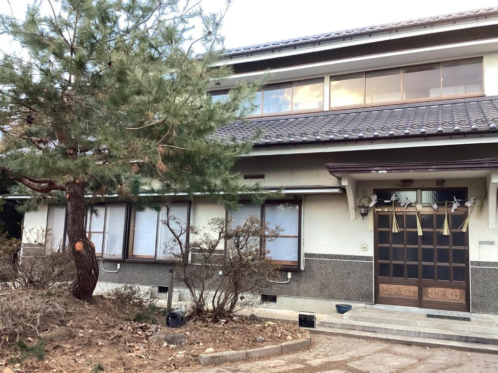 a building with a tree in front of it at 森のしずく in Azumino