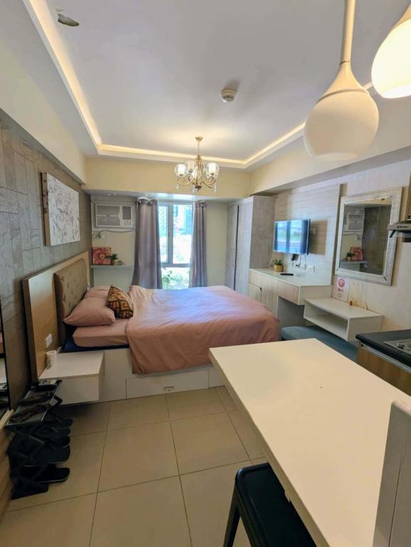 a bedroom with a bed and a desk in it at Janeeka's Airie Avida Riala Cebu in Cebu City