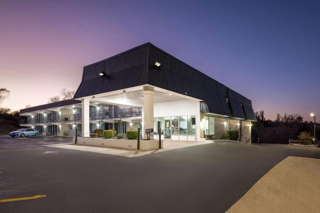 a building with a black roof and a parking lot at Super 8 by Wyndham Kingsport /I-81 in Kingsport