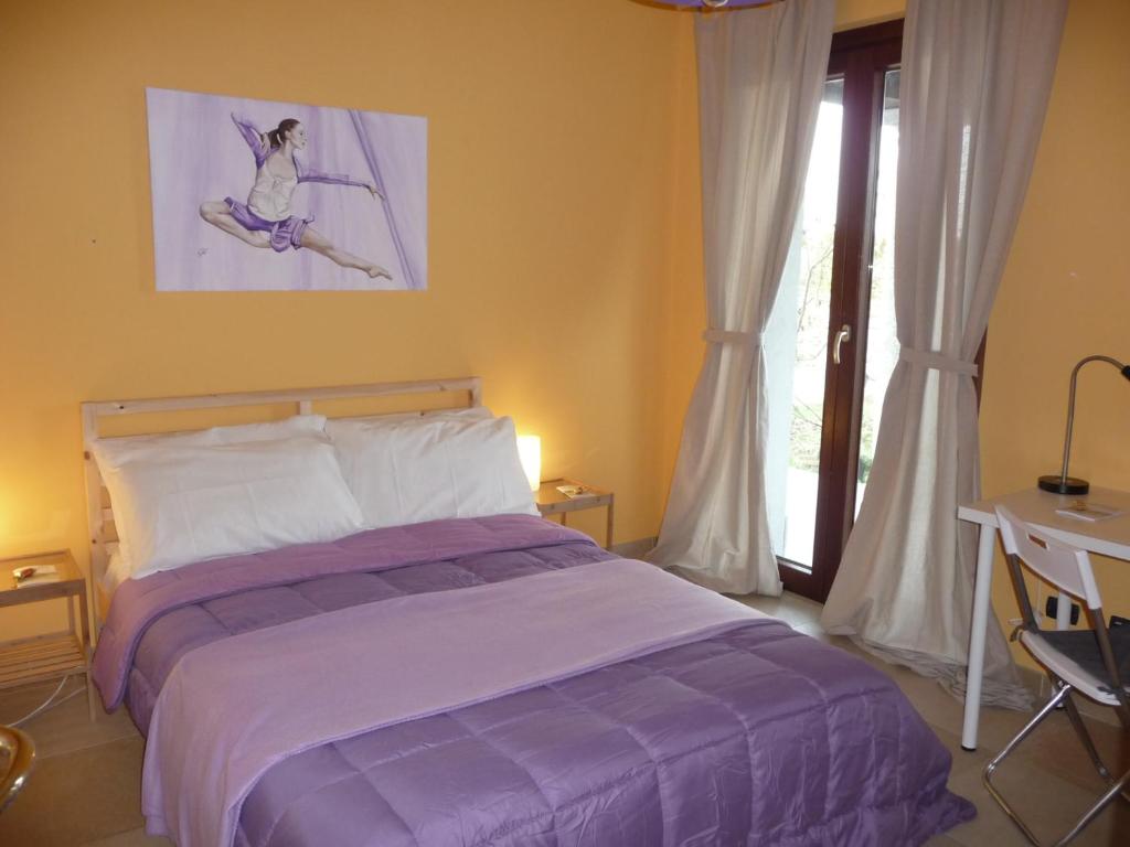 1 dormitorio con cama, escritorio y ventana en Ametista, en Casaleggio Novara