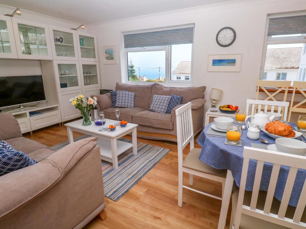 a living room with a couch and a table at Atlantic Waves in Carbis Bay