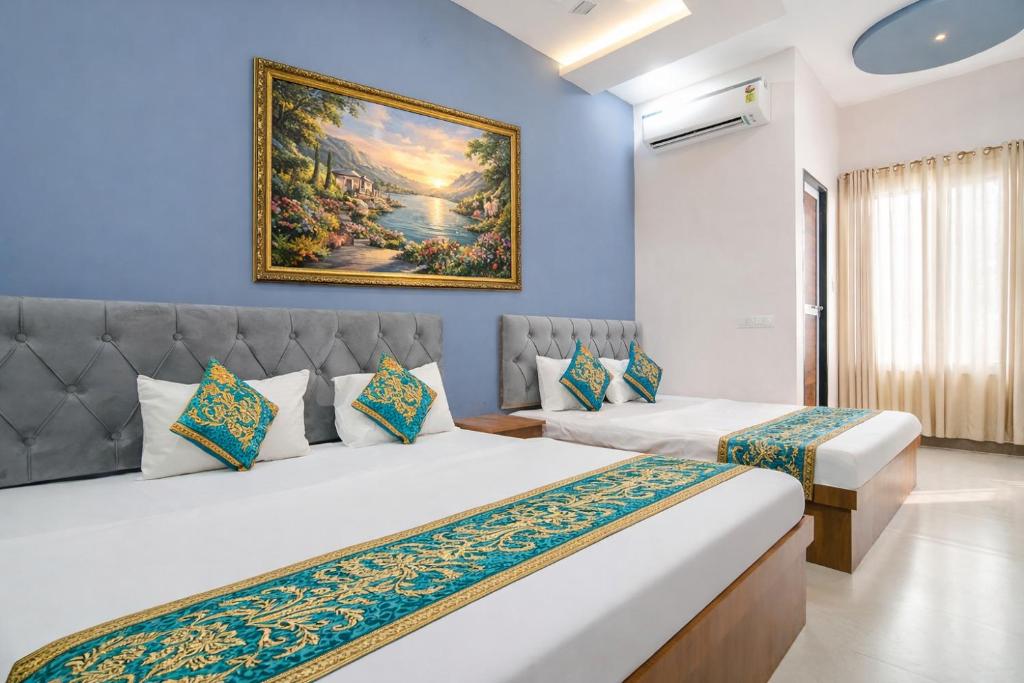 a bedroom with two beds and a painting on the wall at Hotel Tirupati Heights Ujjain # Near Railway Station # Top Rated Property in Ujjain