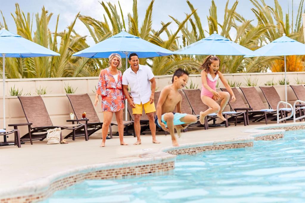 a family standing on the edge of a swimming pool at Hyatt Regency Orange County in Anaheim